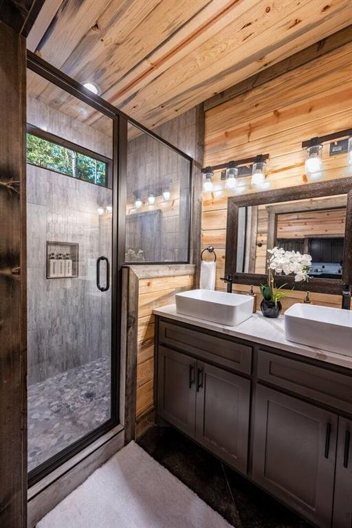 bathroom with vanity, wooden ceiling, walk in shower, and wooden walls