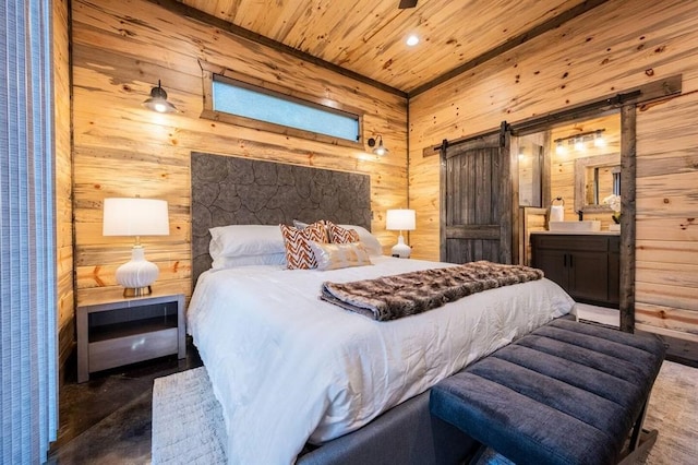 180 Alumacraft Trl, Broken Bow, OK 74728 - bedroom with a barn door, wood ceiling, wood walls, ensuite bath, and finished concrete floors
