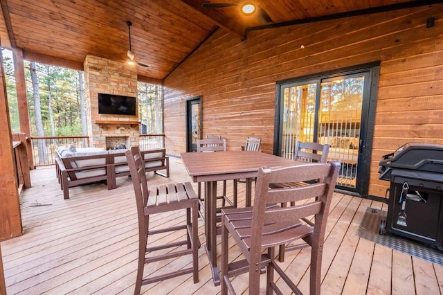 wooden terrace featuring an outdoor living space with a fireplace, grilling area, and ceiling fan