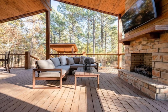 wooden terrace featuring an outdoor living space with a fireplace