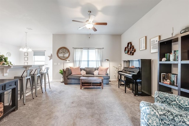 living room featuring ceiling fan with notable chandelier and light carpet