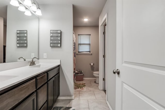 bathroom with toilet, vanity, an inviting chandelier, and tile patterned flooring