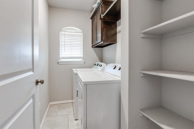 washroom with cabinets, separate washer and dryer, and light tile patterned floors