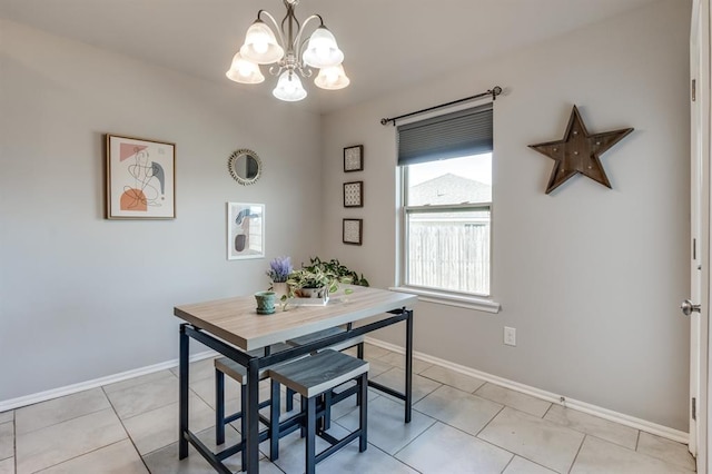 dining area with light tile patterned flooring, a notable chandelier, and baseboards