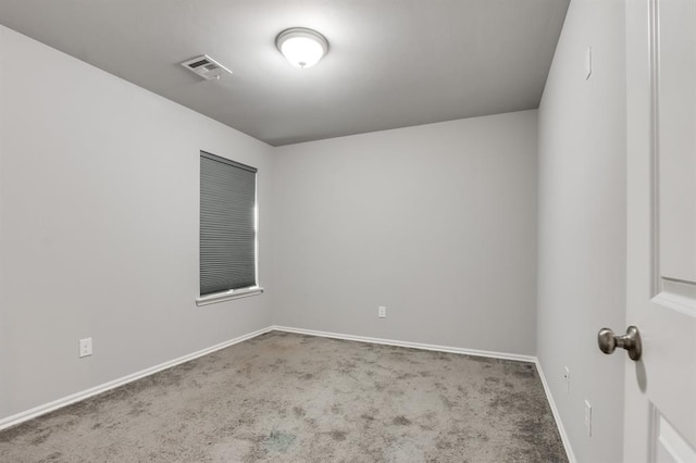 carpeted empty room featuring baseboards and visible vents