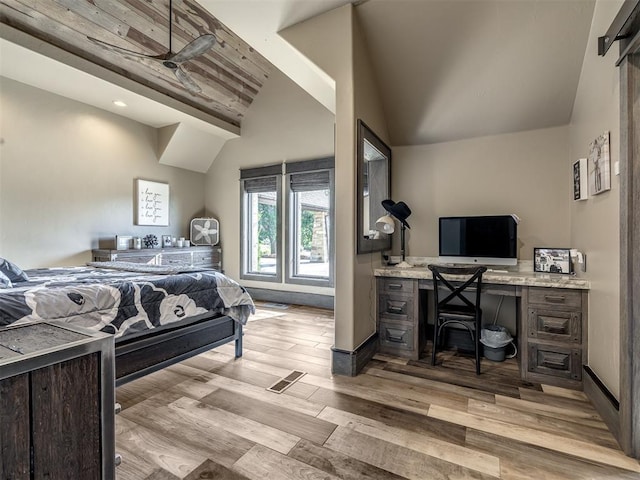 bedroom with light wood-type flooring and vaulted ceiling