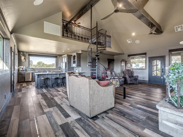 living room with beam ceiling, dark hardwood / wood-style flooring, and high vaulted ceiling