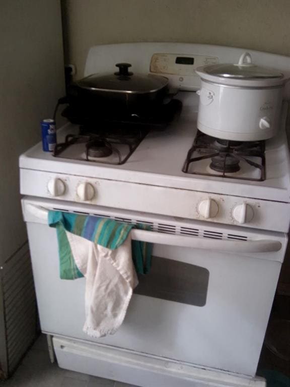 interior details featuring white cabinets and white gas range