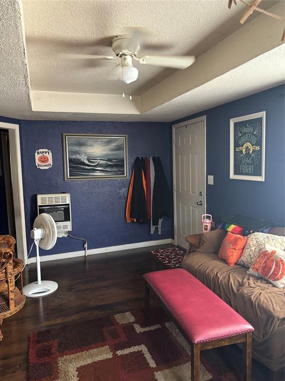 living room featuring a raised ceiling, dark hardwood / wood-style floors, ceiling fan, a textured ceiling, and heating unit