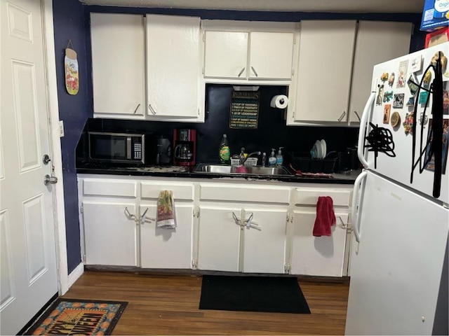 kitchen with dark wood-type flooring, white cabinets, sink, decorative backsplash, and white fridge