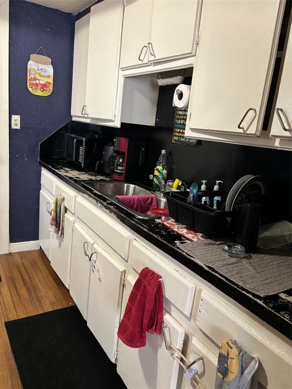 kitchen with white cabinets and wood-type flooring