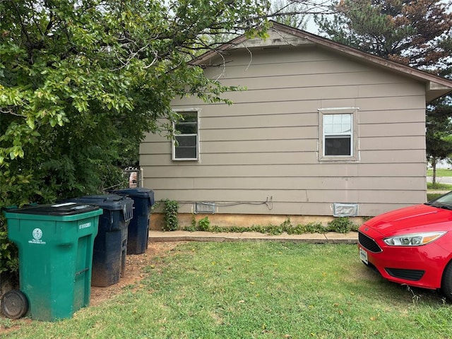 view of side of home with a yard