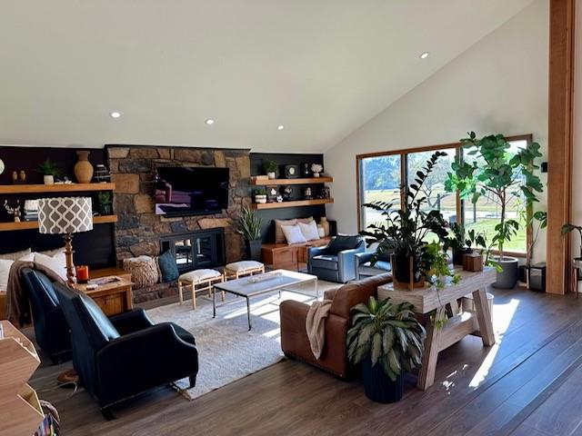 living room featuring a fireplace, dark hardwood / wood-style flooring, and high vaulted ceiling