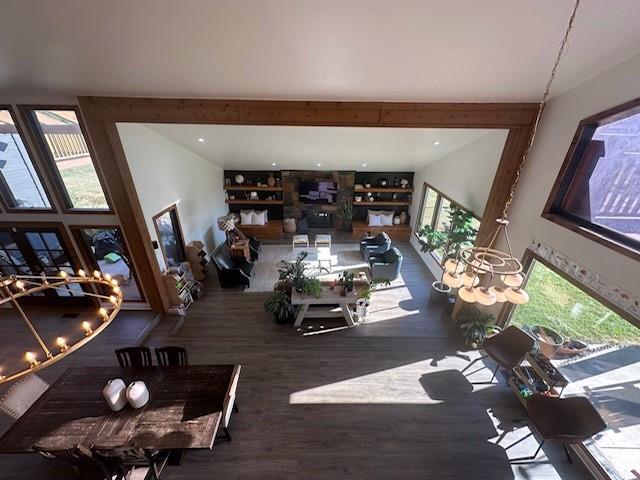 living room with a notable chandelier, a healthy amount of sunlight, and dark wood-type flooring