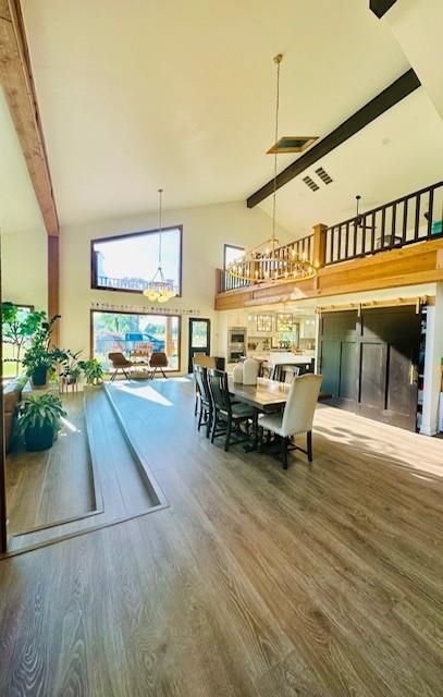 dining area featuring beamed ceiling, wood-type flooring, and high vaulted ceiling