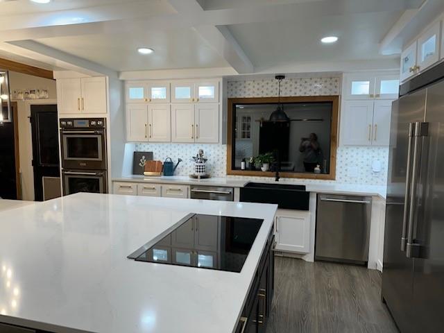 kitchen featuring decorative backsplash, decorative light fixtures, white cabinetry, and black appliances