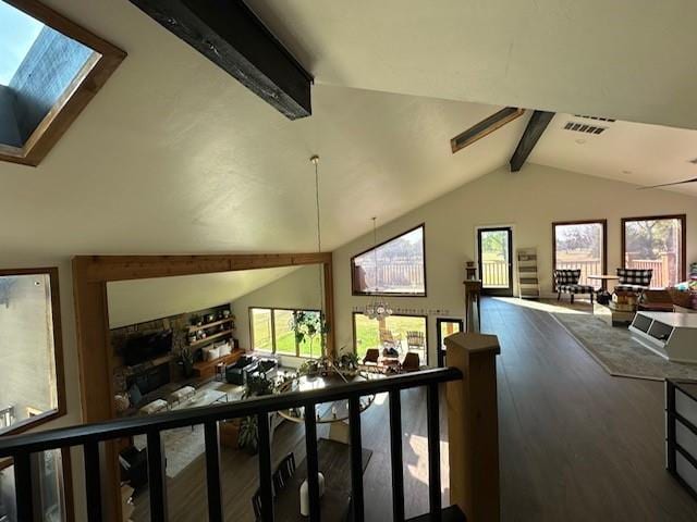 hall with plenty of natural light, wood-type flooring, and lofted ceiling with skylight