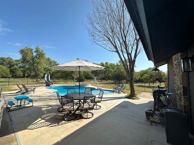 view of swimming pool with a patio area and a water slide