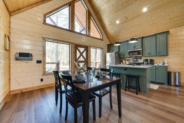 dining space with wood walls, a healthy amount of sunlight, and dark hardwood / wood-style floors