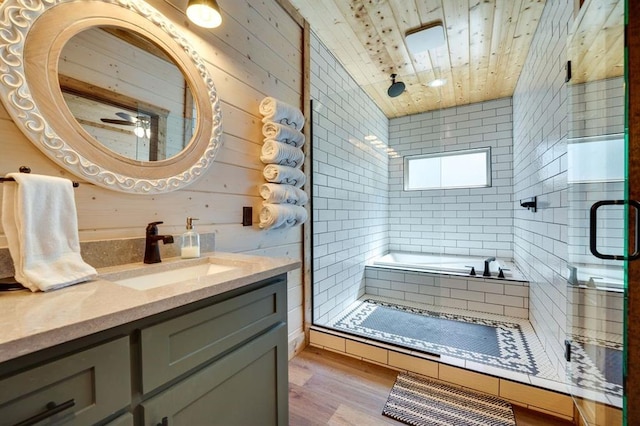 bathroom with wood walls, hardwood / wood-style floors, vaulted ceiling, vanity, and independent shower and bath