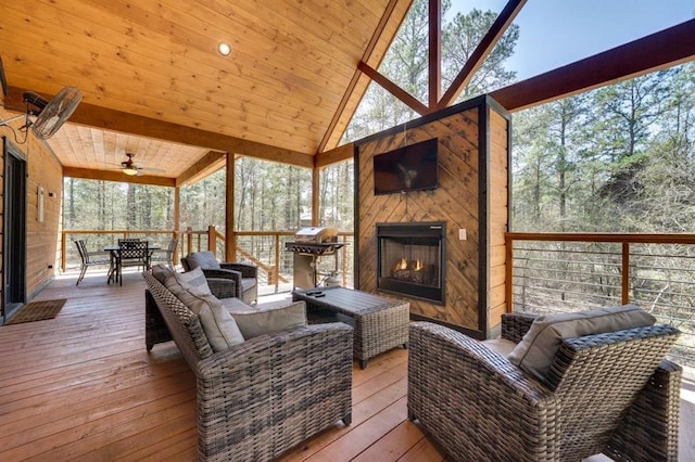 sunroom featuring exterior fireplace, wooden ceiling, a wealth of natural light, and lofted ceiling