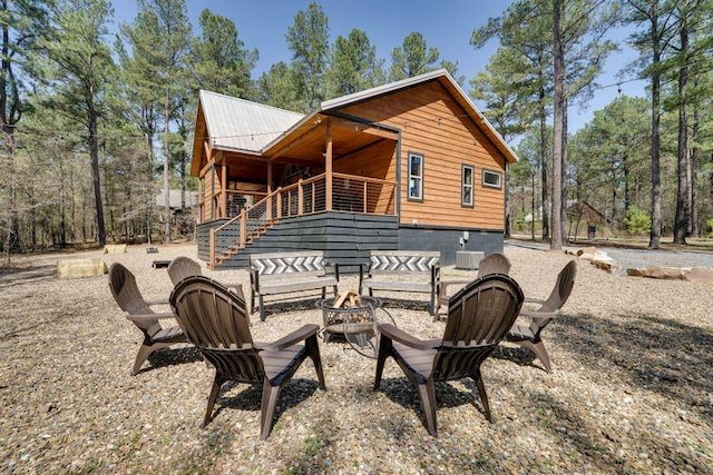 rear view of property with an outdoor fire pit