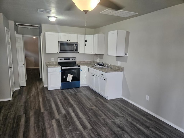 kitchen with sink, white cabinets, dark wood-type flooring, and appliances with stainless steel finishes