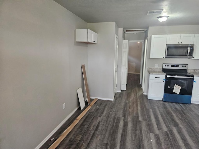 kitchen with dark hardwood / wood-style flooring, white cabinets, and stainless steel appliances