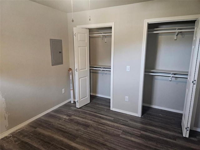 unfurnished bedroom featuring dark wood-type flooring and electric panel