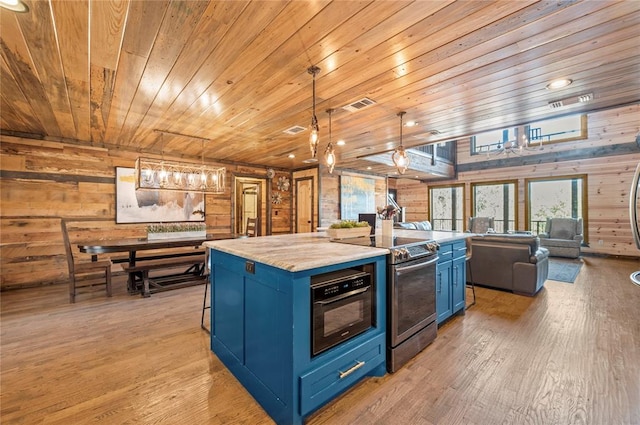 kitchen featuring stainless steel range with electric stovetop, wood walls, light wood finished floors, and blue cabinetry