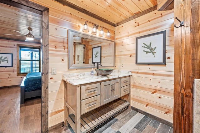 bathroom with wooden ceiling, connected bathroom, wooden walls, wood finished floors, and vanity