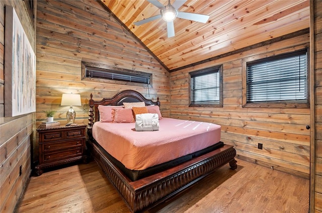 bedroom featuring lofted ceiling, wood walls, light wood-type flooring, and wood ceiling