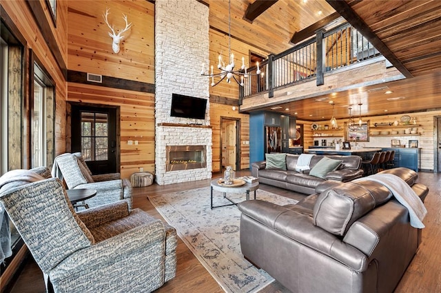 living area with wooden ceiling, wooden walls, a chandelier, and a fireplace