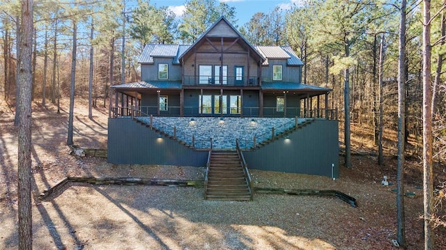 rear view of property with metal roof and stairs