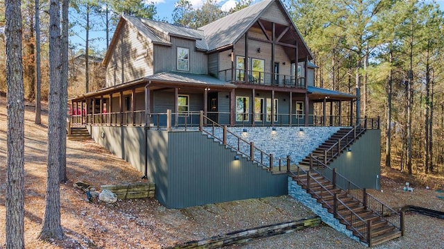 view of front facade featuring a porch, metal roof, and stairs