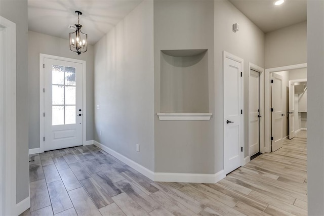 foyer entrance with a notable chandelier and light hardwood / wood-style floors