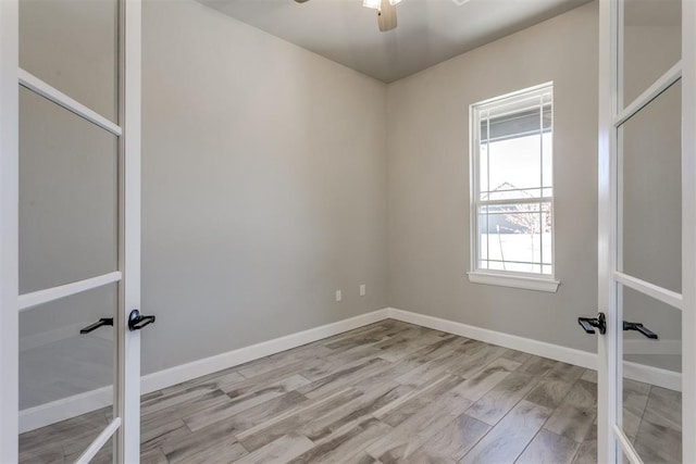 unfurnished room with ceiling fan, light wood-type flooring, and french doors