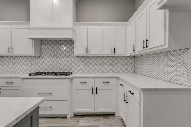 kitchen featuring white cabinetry, light wood-type flooring, and light stone countertops