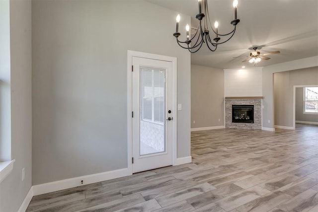 unfurnished living room with light hardwood / wood-style flooring and ceiling fan with notable chandelier