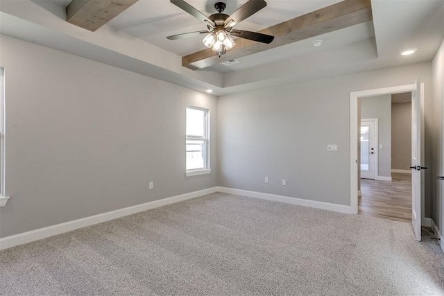 carpeted empty room featuring beam ceiling, a tray ceiling, and ceiling fan