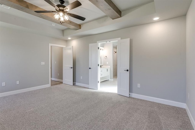 unfurnished bedroom featuring ceiling fan, beam ceiling, light colored carpet, and ensuite bath