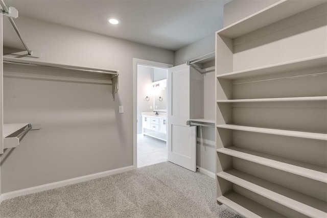 spacious closet featuring light carpet