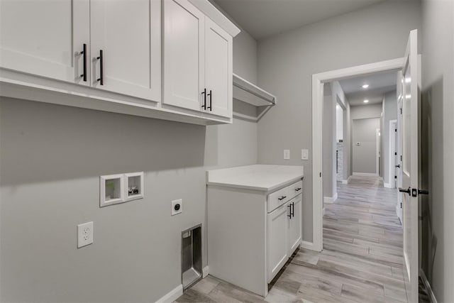 washroom with washer hookup, light hardwood / wood-style flooring, cabinets, and hookup for an electric dryer