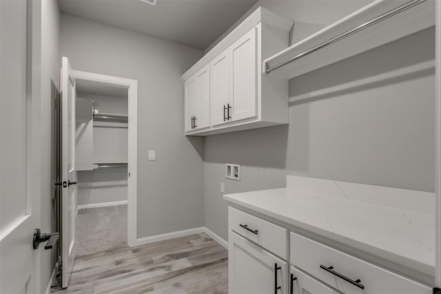 laundry room featuring cabinets, hookup for a washing machine, and light wood-type flooring