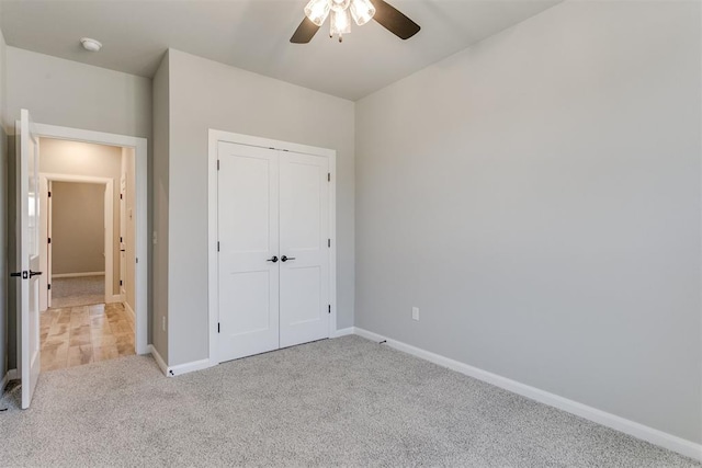 unfurnished bedroom featuring a closet, light colored carpet, and ceiling fan