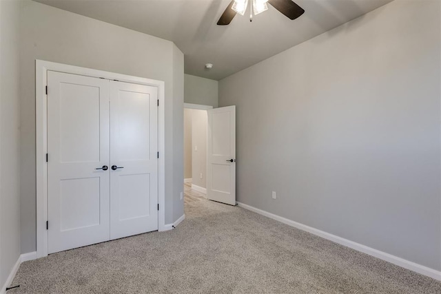 unfurnished bedroom featuring ceiling fan, a closet, and light colored carpet