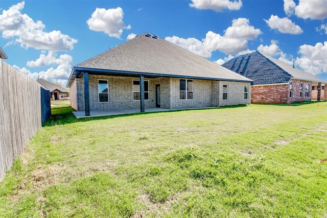 rear view of property featuring a lawn and a patio