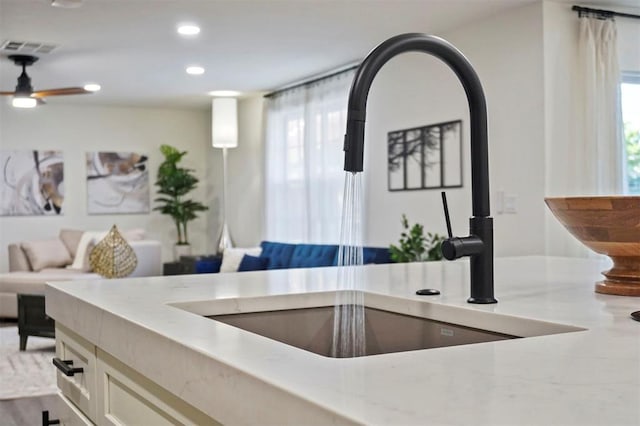 kitchen featuring ceiling fan, plenty of natural light, and sink