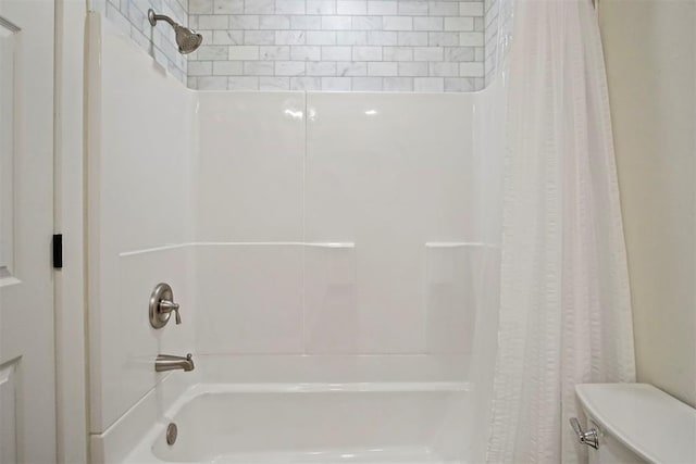 bathroom featuring toilet and shower / tub combo with curtain