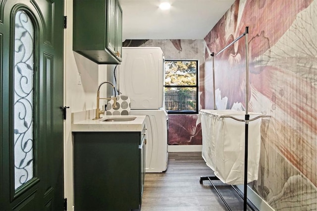 bathroom with wood-type flooring, vanity, and stacked washer and clothes dryer